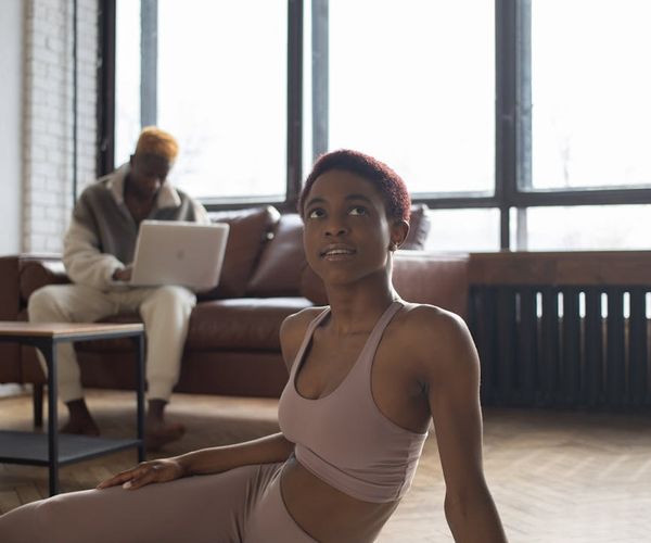 A person in comfortable sportswear meditating on a yoga mat.